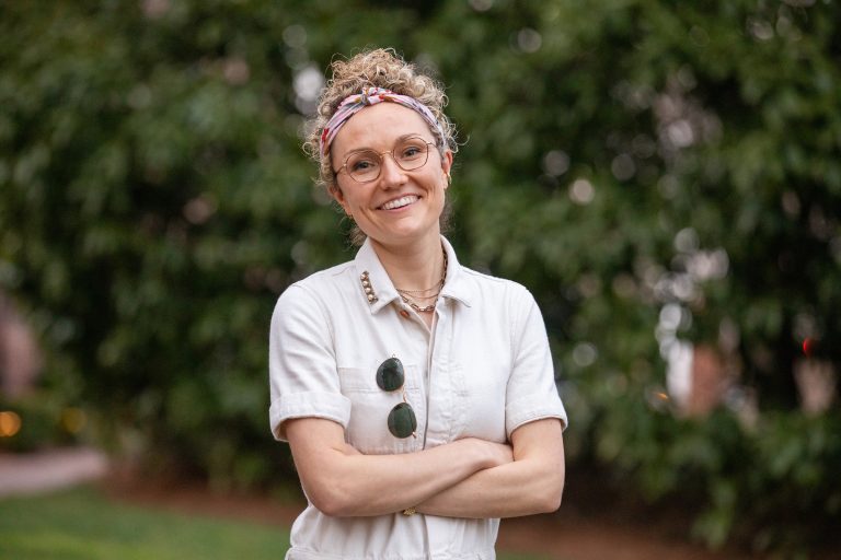 Mackenzie Thomas stands outside with arms crossed.