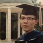 Cliff Huang poses by the Old Well to commemorate the earning of his doctorate from UNC-Chapel Hill in 1968.